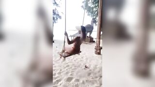 NinaCola3 wearing T-back playing the swing on the beach