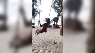 NinaCola3 wearing T-back playing the swing on the beach