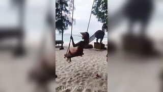 NinaCola3 wearing T-back playing the swing on the beach