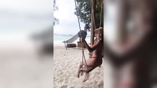 NinaCola3 wearing T-back playing the swing on the beach