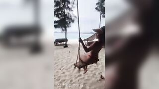 NinaCola3 wearing T-back playing the swing on the beach